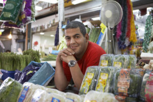 Portrait,of,confident,male,grocery,store,owner,smiling,while,leaning