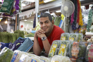 Portrait,of,confident,male,grocery,store,owner,smiling,while,leaning